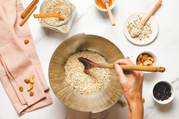 Zelfgemaakte granola maken Kom havermout met noten en honing op witte marmeren tafel