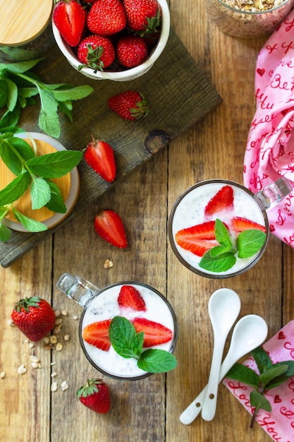 Zelfgemaakte granola met aardbeienyoghurt chiazaden en verse bessen op een rustieke tafel bovenaanzicht