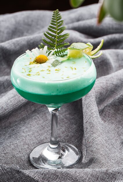 Zelfgemaakte groene cocktail met wei, wit ei op grijs