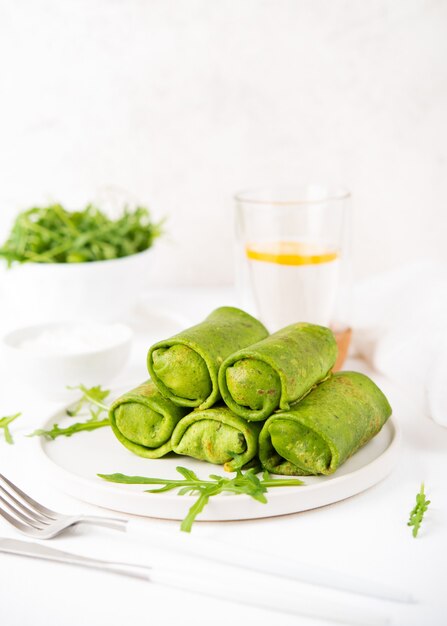 Zelfgemaakte groene vegetarische pannenkoeken met vulling, plantaardig voedsel, spinaziepannenkoekjes