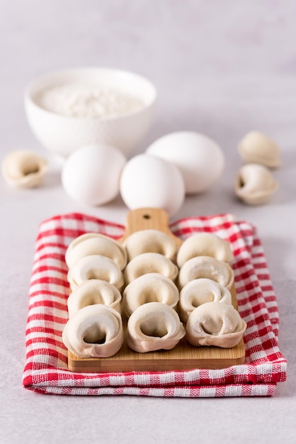 Zelfgemaakte Halfafgewerkte Pelmeni Dumplings op de Servet Ingrediënten voor het Koken Pelmeni Grijze Achtergrond Verticaal