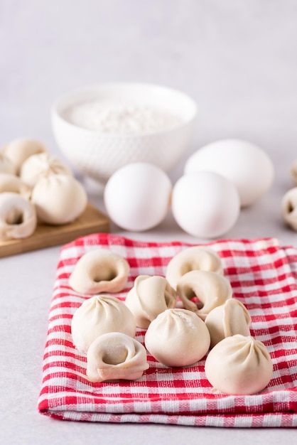 Zelfgemaakte Halfafgewerkte Pelmeni Dumplings op de Servet Ingrediënten voor het Koken Pelmeni Grijze Achtergrond Verticaal