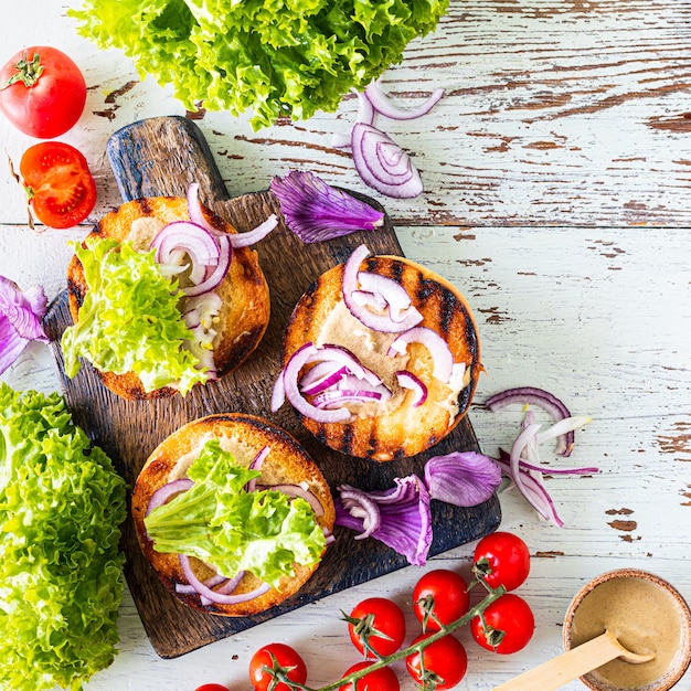 Zelfgemaakte hamburger maken. ingrediënten voor het koken op een houten tafel. Bovenaanzicht.