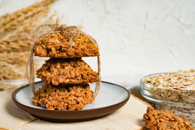 Zelfgemaakte havermoutkoekjes met pinda's en rozijnen op de keukentafel witte achtergrond vrije ruimte voor tekst Stapel havermoutkoekjes close-up kopie ruimte Hoge kwaliteit foto