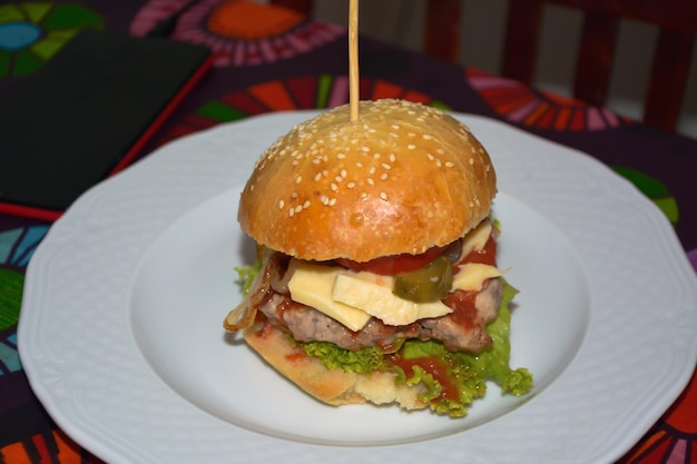 Zelfgemaakte heerlijke sandwich gemaakt van broodjes met sesamzaadjes gevuld met vlees, komkommers, tomaten