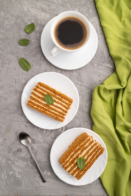 Zelfgemaakte honing cake met melk room en munt met een kopje koffie