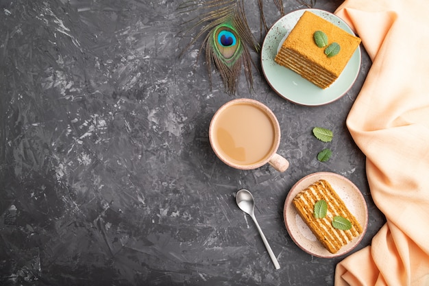 Zelfgemaakte honing cake met melk room en munt met een kopje koffie