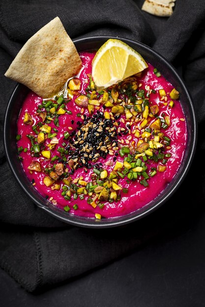 Zelfgemaakte Hummus van Bieten en Kikkererwten Met Groente CruditÃƒÂ©s en Ongezuurd Brood op Donkere Achtergrond