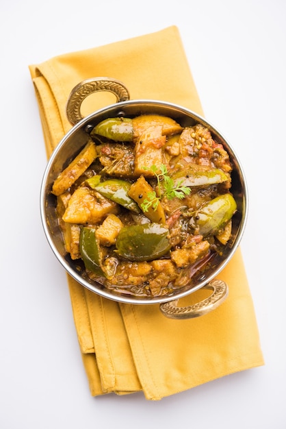 Zelfgemaakte Indiase pittige aubergine en aardappelcurry, ook bekend als aloo Baigan ki sabzi in het Hindi, geserveerd in kadhai of witte kom, selectieve focus