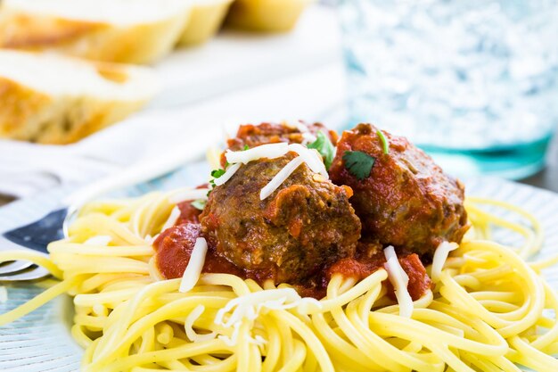 Zelfgemaakte Italiaanse gehaktballen gegarneerd met koriander en Parmezaanse kaas over spaghetti voor het diner.