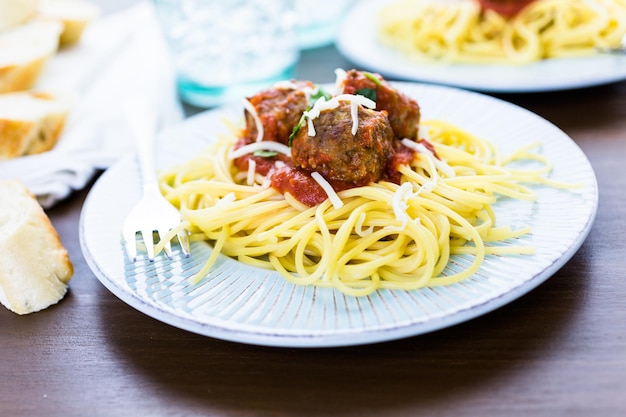 Zelfgemaakte Italiaanse gehaktballen gegarneerd met koriander en Parmezaanse kaas over spaghetti voor het diner.