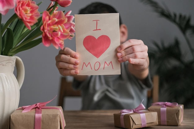 Zelfgemaakte kaart voor mama in de handen van een jongen Fijne Moederdag