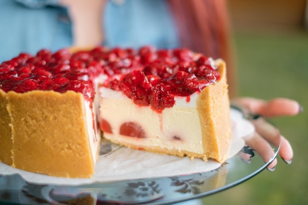 Zelfgemaakte kersencake op glasplaat Levering van eten Zelfgemaakt bakken Vrouw houdt cake in handen