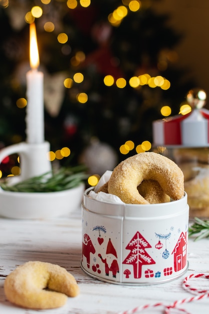 Zelfgemaakte kerst bakkerij, vanille halve maan koekjes met kaarsen, kerstboom en bokeh