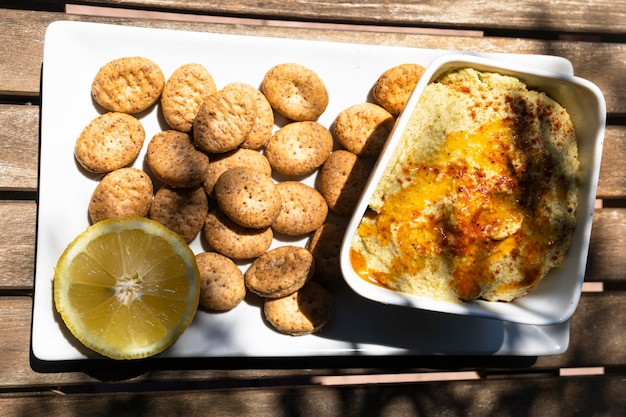 Zelfgemaakte kikkererwtenhummus met crackers op een tuintafel. Gezonde veganistische snack