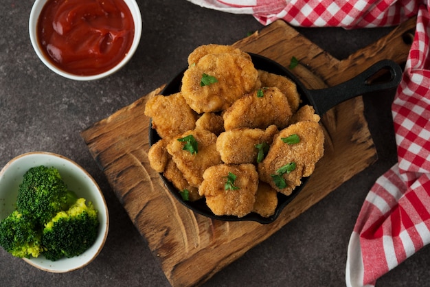 Foto zelfgemaakte kipnuggets met groenten op een houten bord