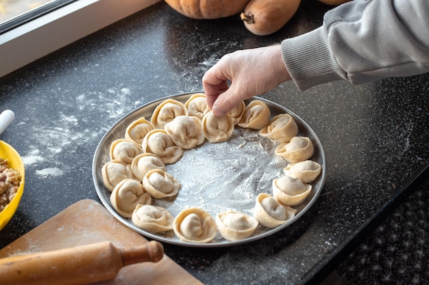 Zelfgemaakte knoedels koken Een man maakt knoedels en legt ze op een dienblad