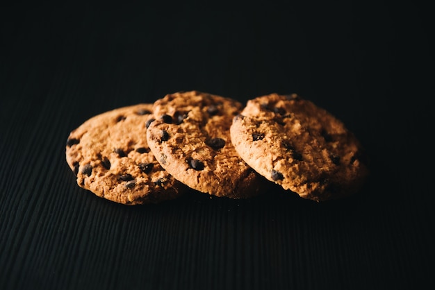 Zelfgemaakte koekjes gestapeld in een stapel op de tafel, op donkere ondergrond