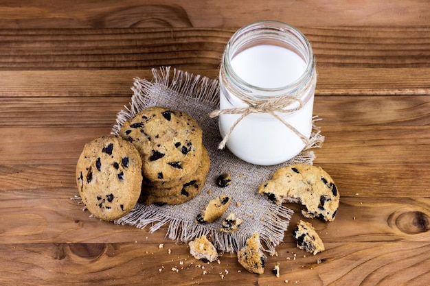 Zelfgemaakte koekjes met een fles melk op een houten tafel