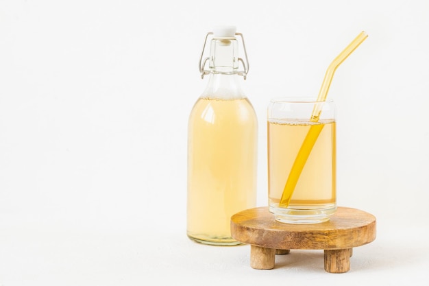 Zelfgemaakte kombucha gefermenteerde drank in glas en fles op witte achtergrond Heathy probiotische drank