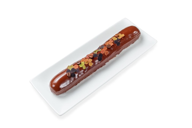 Zelfgemaakte lange met chocolade bedekte eclairs en koffie in een bord op een witte geïsoleerde achtergrond