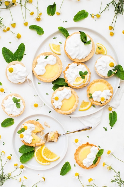 Zelfgemaakte lemon curd-taartjes met meringue en muntblaadjes