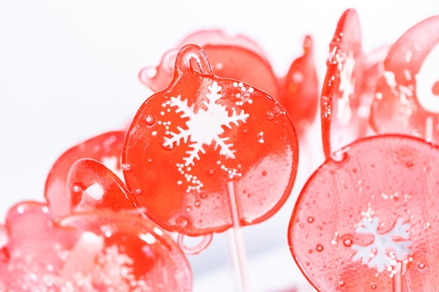 Zelfgemaakte lolly's met bessensmaak met sneeuwvlokken op een witte lollystokjes.