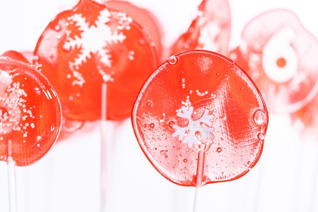 Zelfgemaakte lolly's met bessensmaak met sneeuwvlokken op een witte lollystokjes.