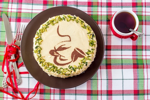 Zelfgemaakte mokka koffiecake met botercrème en pistache witte mok in rood gebreid shirt bovenaanzicht