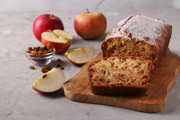 Zelfgemaakte muffin met appels en rozijnen op een houten bord op een grijs