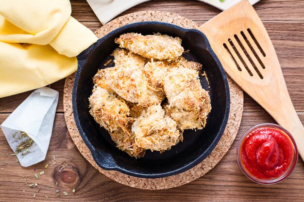 Zelfgemaakte nuggets van kip in een koekenpan