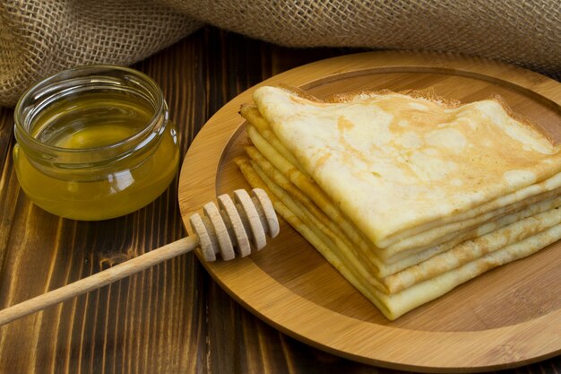 Zelfgemaakte pannenkoeken met honing op de ronde snijplank