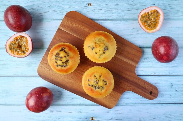 Zelfgemaakte Passievruchten Muffins op Breadboard met verse passievruchten op houten tafel