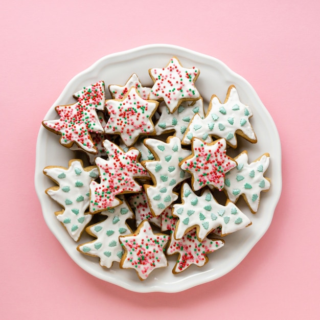 Zelfgemaakte peperkoek kerstkoekjes in de vorm van sterren en bomen op een witte plaat
