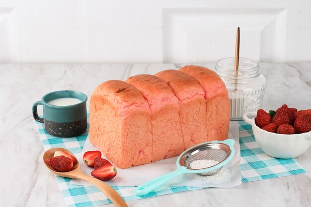 Zelfgemaakte Pink Loaf Aardbeienbrood voor Sandwich Ontbijt. Geserveerd met melk en verse aardbeien. Kopieer ruimte voor tekst of advertentie