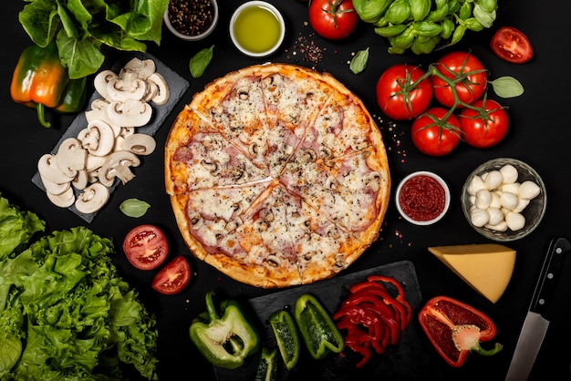 Zelfgemaakte pizza klaar om te eten met rauwe ingrediënten. Bovenaanzicht