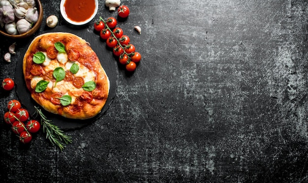 Zelfgemaakte pizza met cherrytomaatjes, spinazie en knoflook