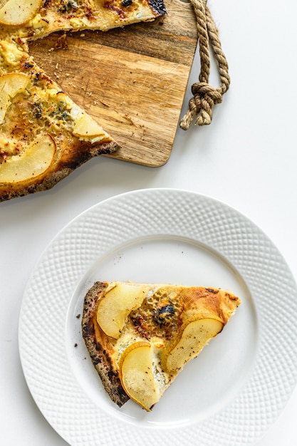 Zelfgemaakte pizza met peren, noten en blauwe kaas. Witte achtergrond. Bovenaanzicht