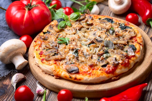 Zelfgemaakte pizza met tomaten, champignons en groene basilicum