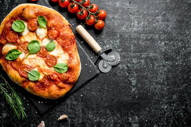 Zelfgemaakte pizza met tomaten op een tak en rozemarijn