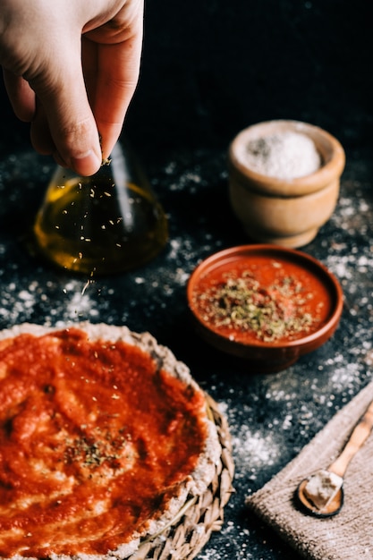 Zelfgemaakte pizzavoorbereiding op oude houten tafel