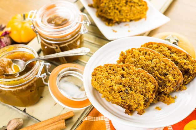 Zelfgemaakte pompoenboter met brood op tafel.