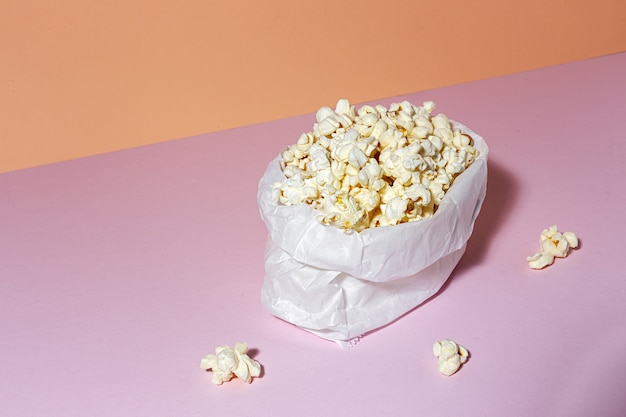 Zelfgemaakte popcorn op gekleurde tafel met hoog contrastlicht. Snack concept