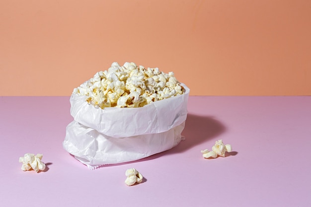 Zelfgemaakte popcorn op gekleurde tafel met hoog contrastlicht. Snack concept