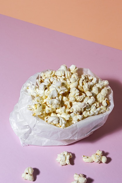 Foto zelfgemaakte popcorn op gekleurde tafel met hoog contrastlicht. snack concept