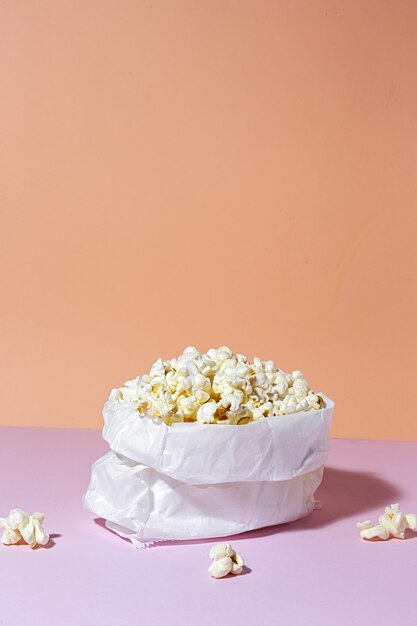 Zelfgemaakte popcorn op gekleurde tafel met hoog contrastlicht. Snack concept