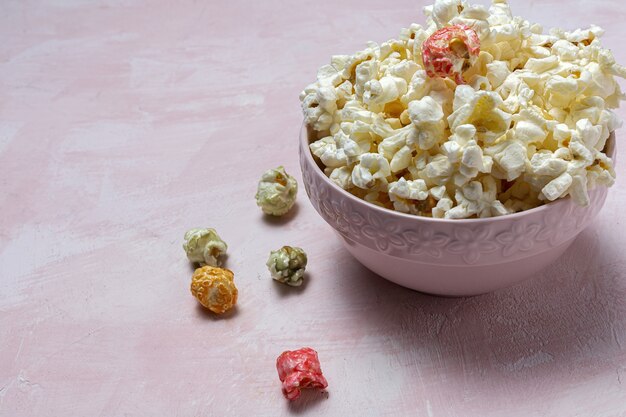 Zelfgemaakte popcorn op gekleurde tafel met hoog contrastlicht. Snack concept