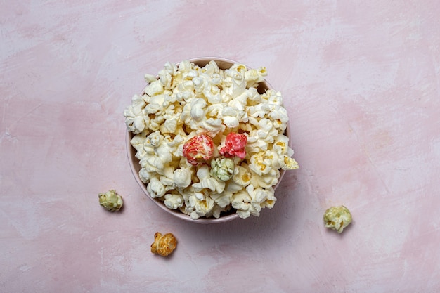 Zelfgemaakte popcorn op gekleurde tafel met hoog contrastlicht. snack concept