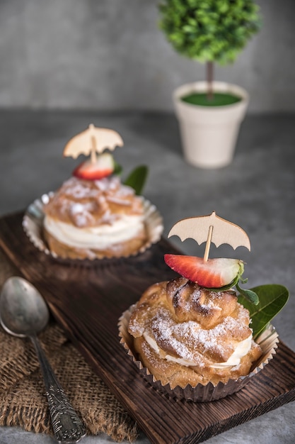 Zelfgemaakte profiteroles met room, aardbeien en munt. Dessert voor fijnproevers.