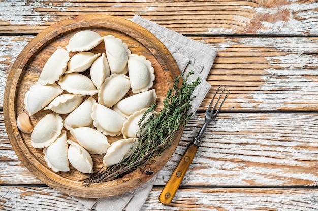 Foto zelfgemaakte rauwe bevroren dumplings, vareniki, pierogi gevuld met aardappel op een houten plank a